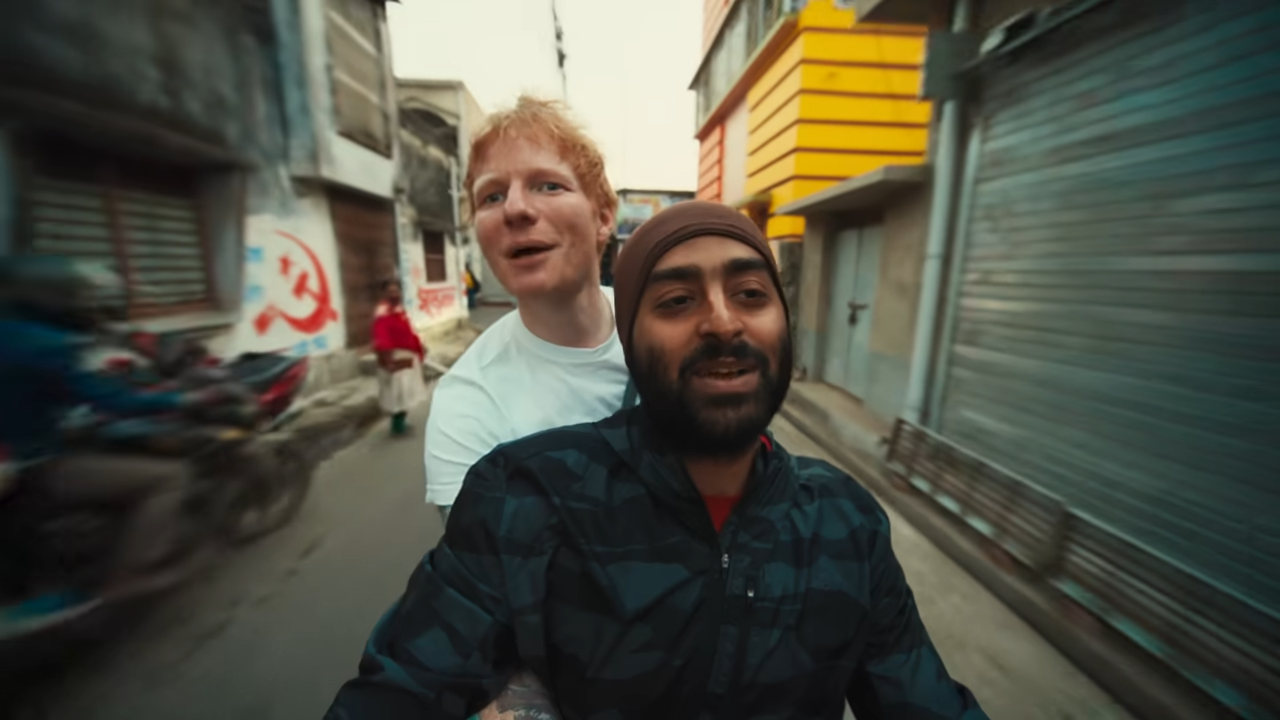 Ed Sheeran and Arijit Singh explore the streets of Jiaganj on a bike. (Still from Ed Sheeran's YouTube channel)