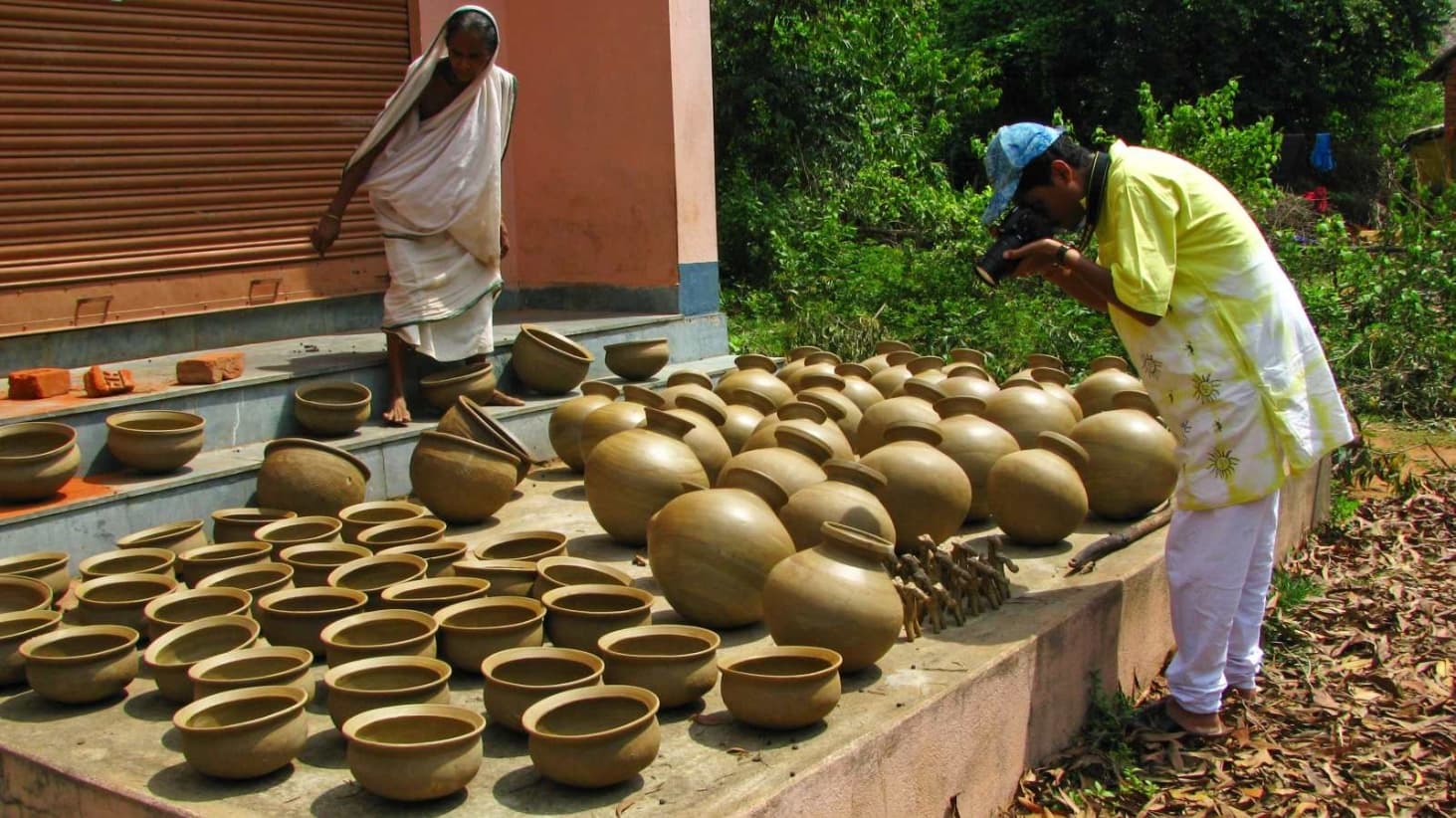 <p>A tourist checks out terracotta pots left to dry naturally in the open.</p>