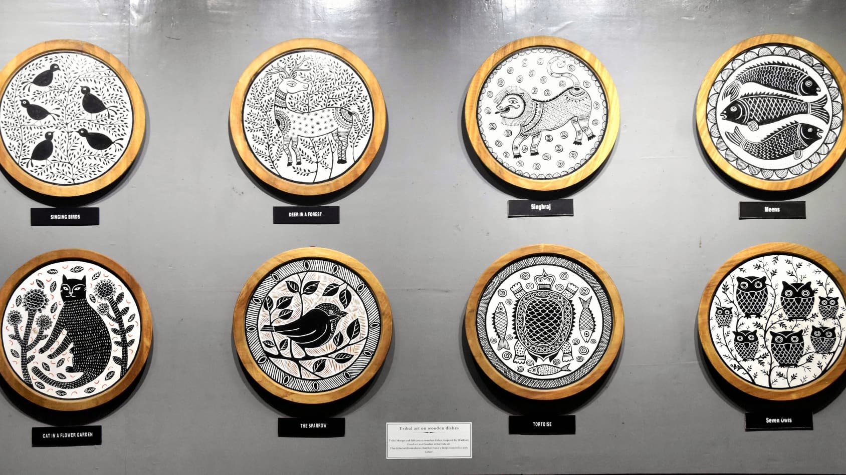 <p>A display featuring intricate tribal art on wooden dishes.</p>