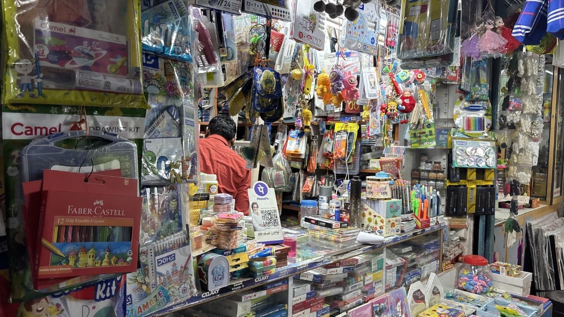 <p>Crayons, sketchbooks, glue sticks and school supplies crowd the shelves of a stationery store.</p>